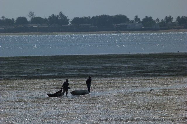 Les pêcheurs tirent leur pirogue sur le sable jusqu'à trouver suffisamment d'eau